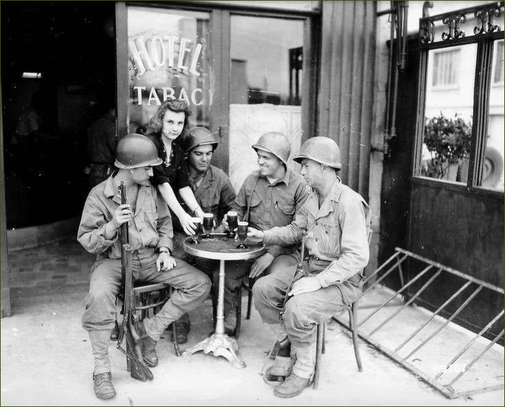 79th Infantry Division's men enjoying time at Mantes-Gassicourt with a french girl.