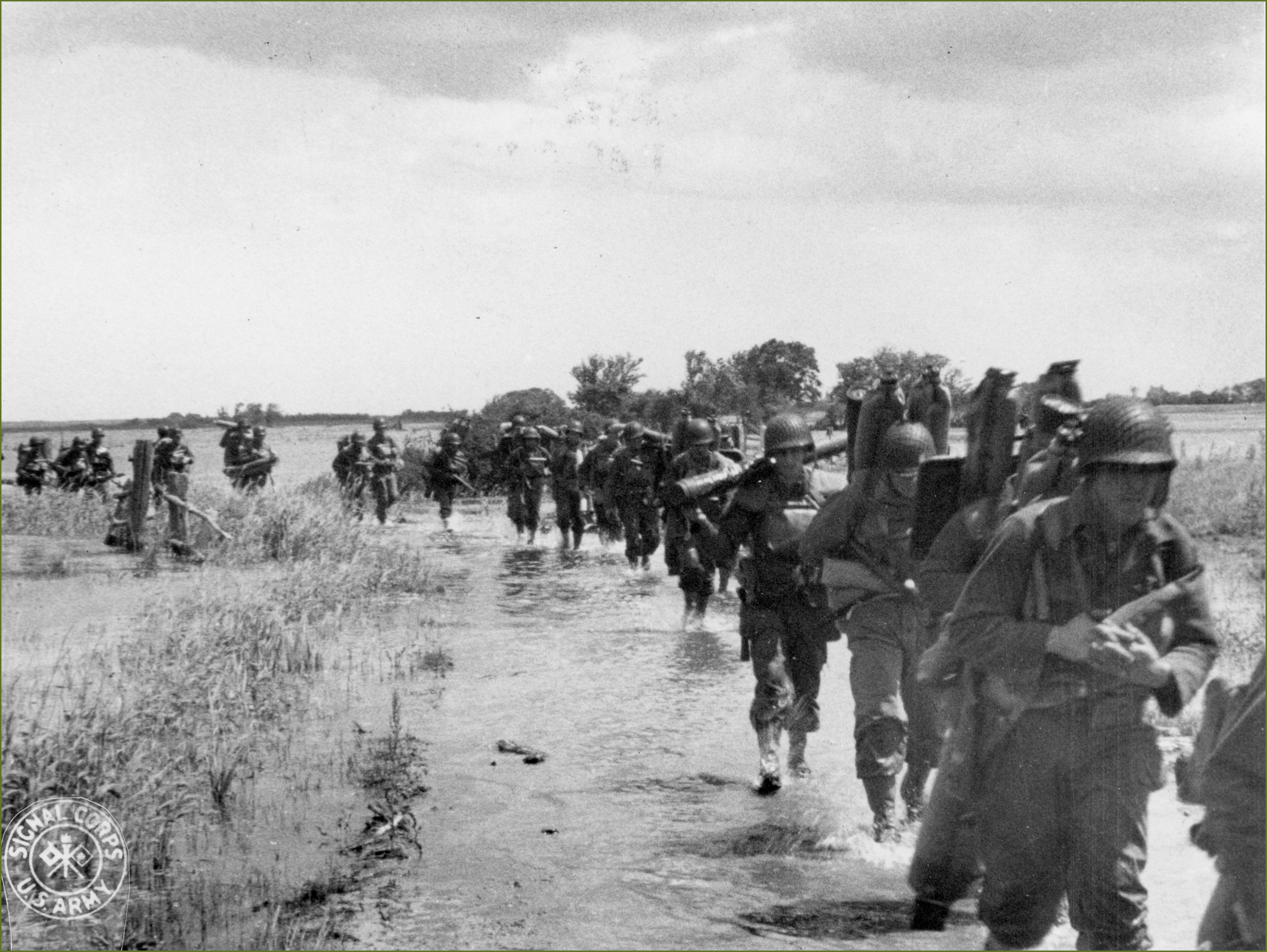 US soldiers disembarking and marching toward the flooded area