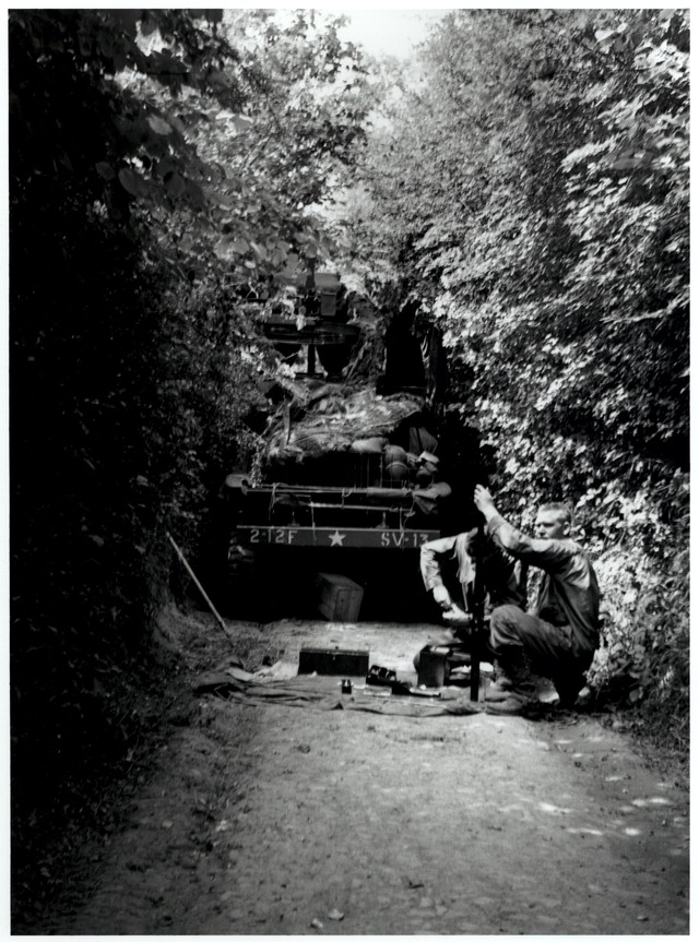 American truck broken down in hedgerow with 2 GIs working on equipment in front of it, Normandy, France.jpg
