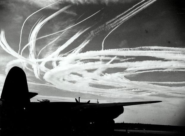 Silhouette of a B-26 with thin vapor trails caused by fighters.jpg