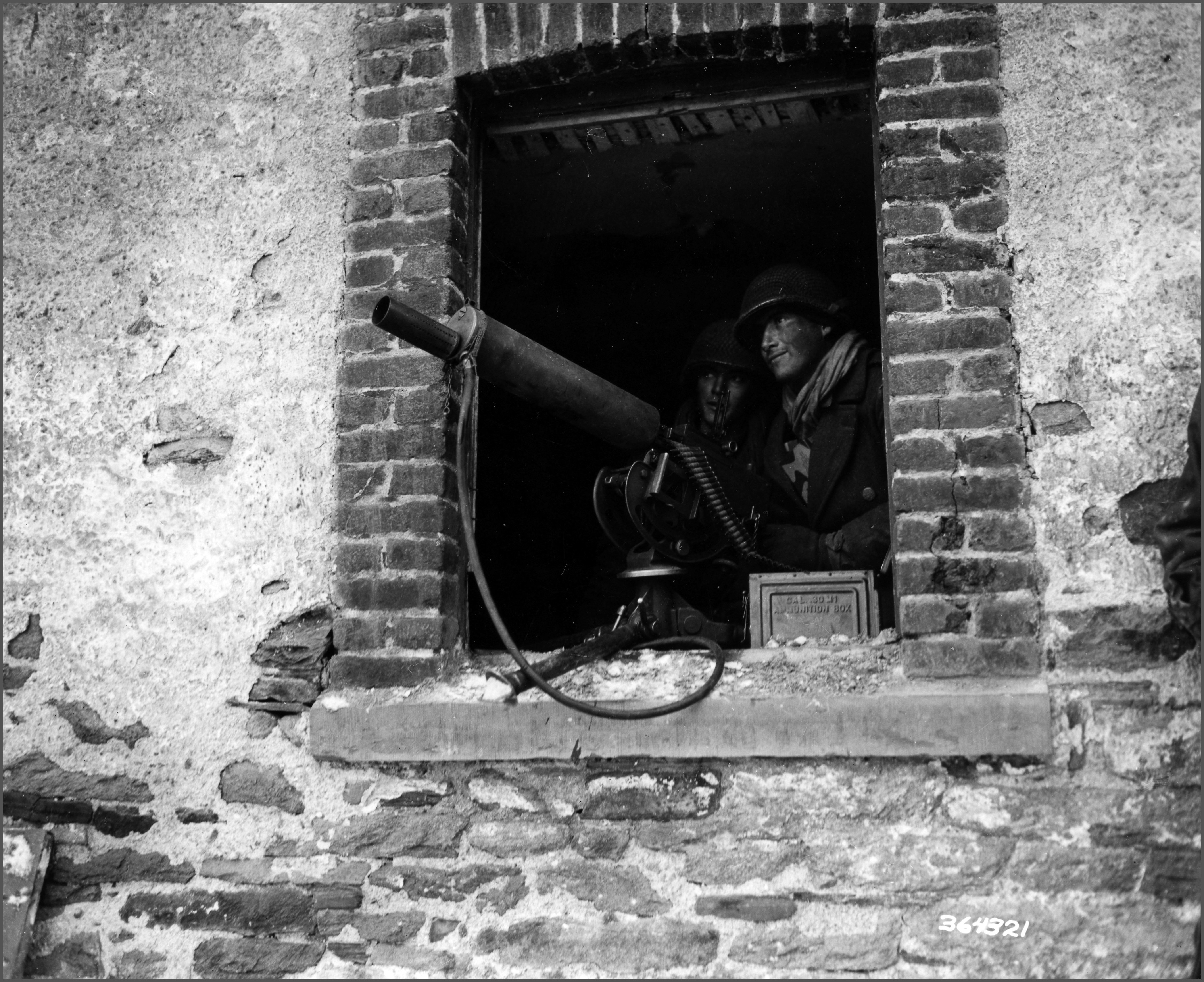 Pfc. Gerald A. Cohan, 9 Shaw Ave., Newark, N.J., mans a .30 caliber machine gun covering approaches to Salmchateau, as the 75th Division takes the town.